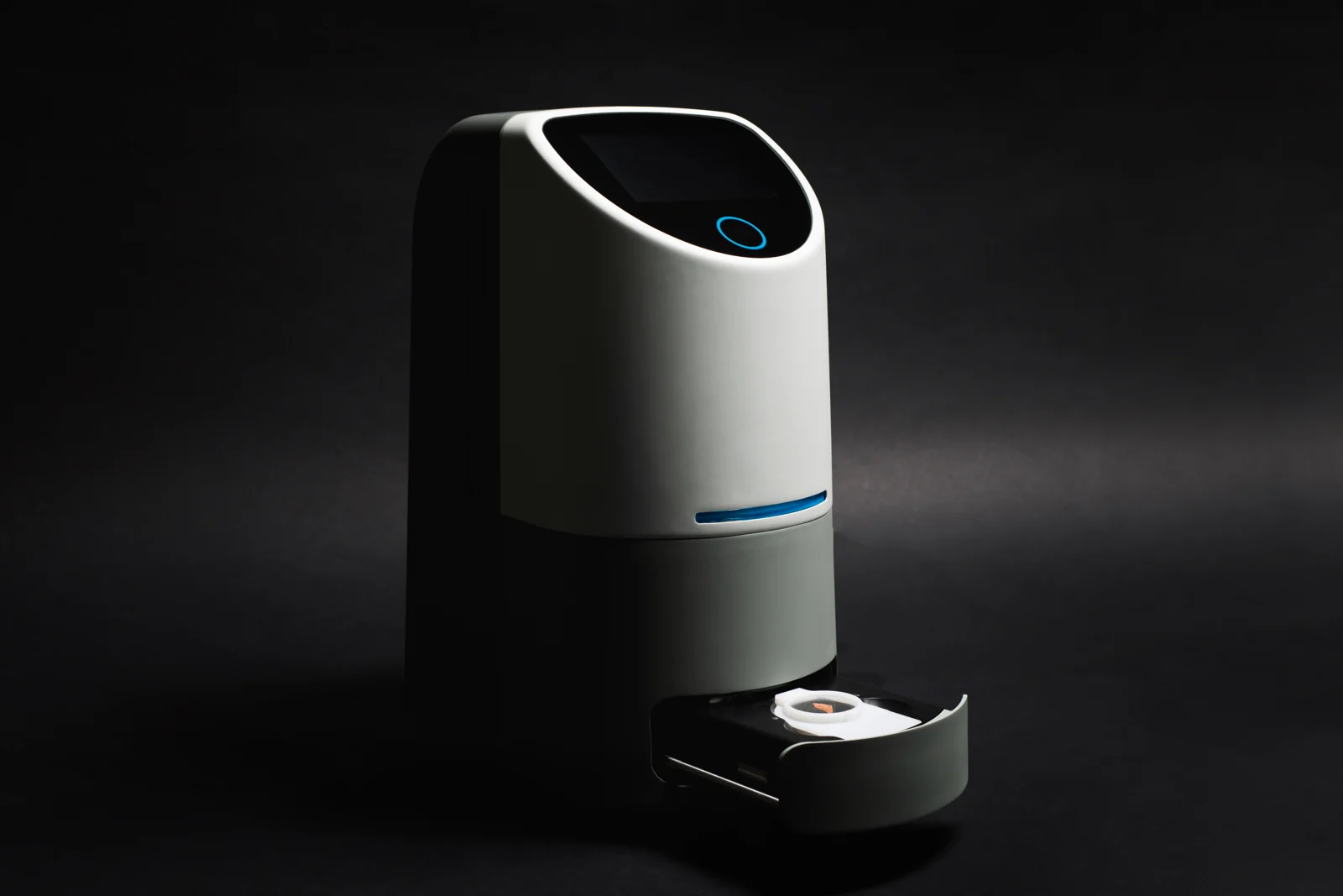 Digital pathology device with an integrated display, illuminated control ring, and open sample drawer.