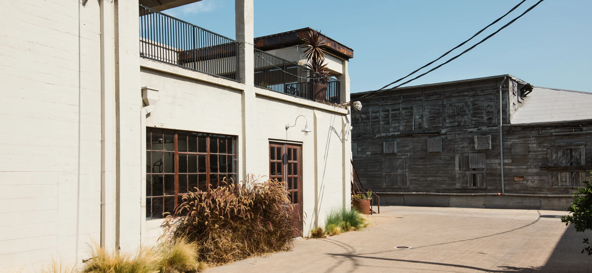 The historic IceHouse studio exterior with industrial windows and neighboring timber buildings in Orange.