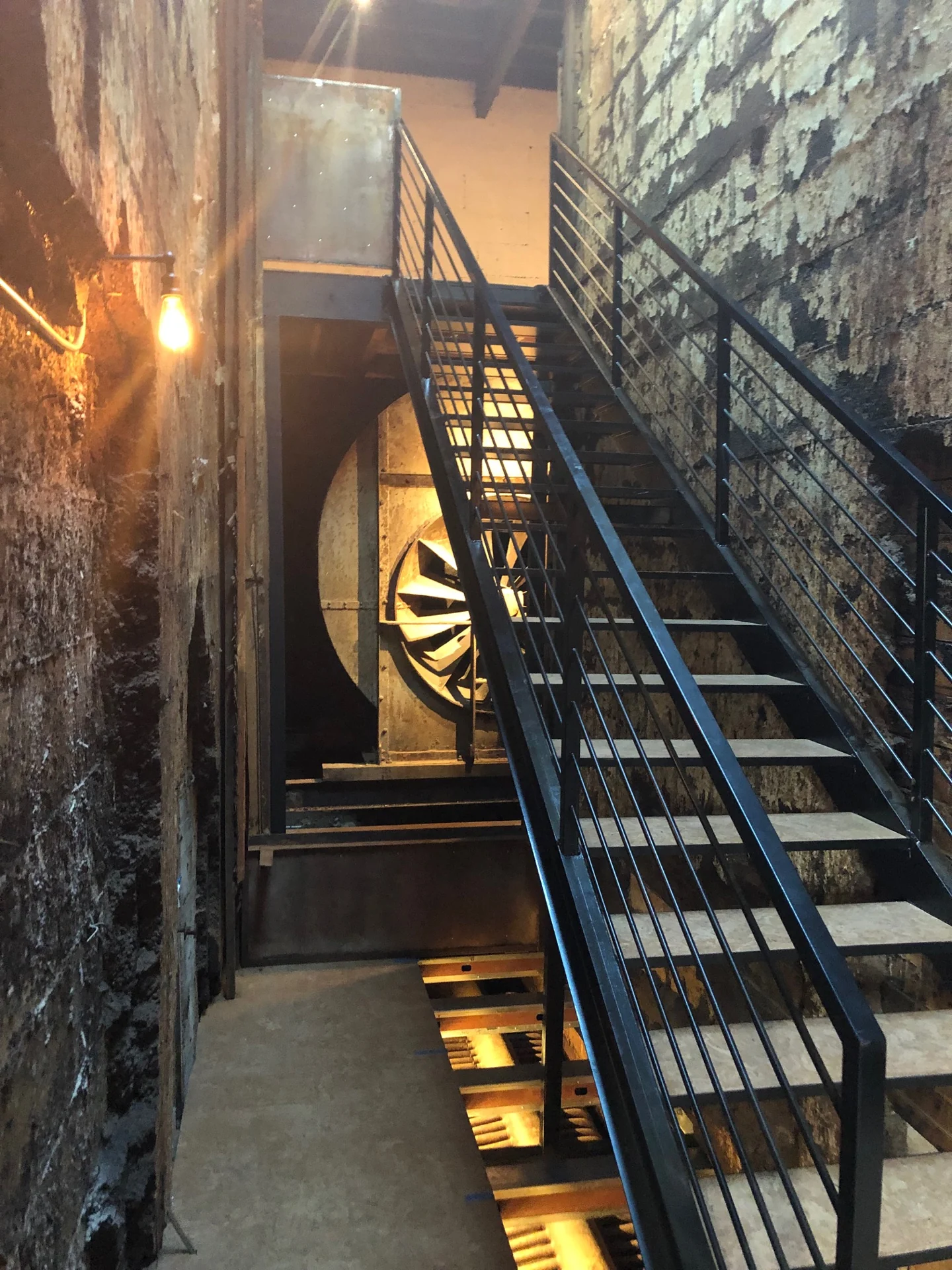 Steel stairs and a preserved industrial fan inside the historic building.